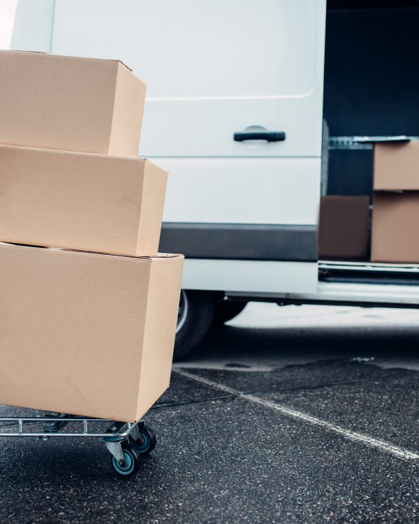 Trolley with cardboard boxes against mail van